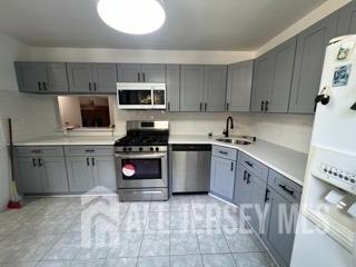 a kitchen with stainless steel appliances a stove sink microwave and cabinets