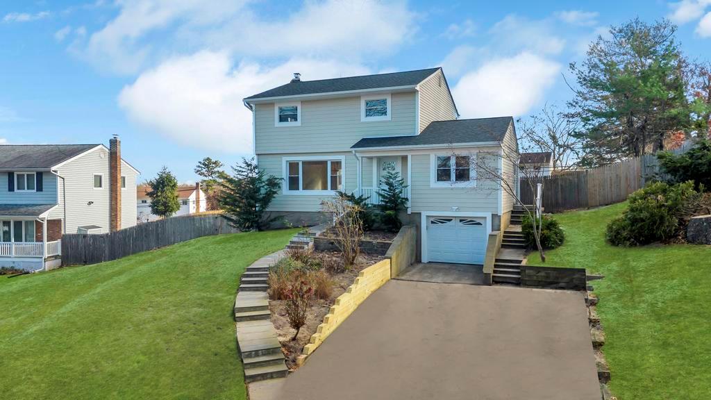 View of front of house with a garage and a front yard