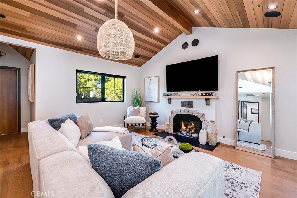 a living room with furniture a fireplace and a flat screen tv