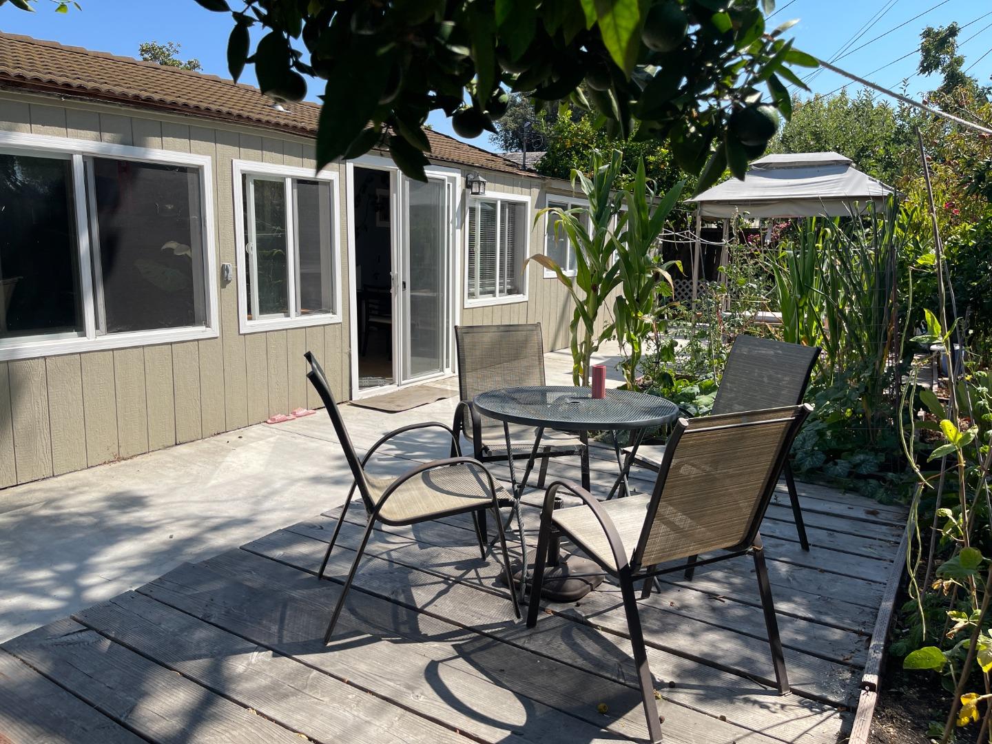 a patio with table and chairs and potted plants