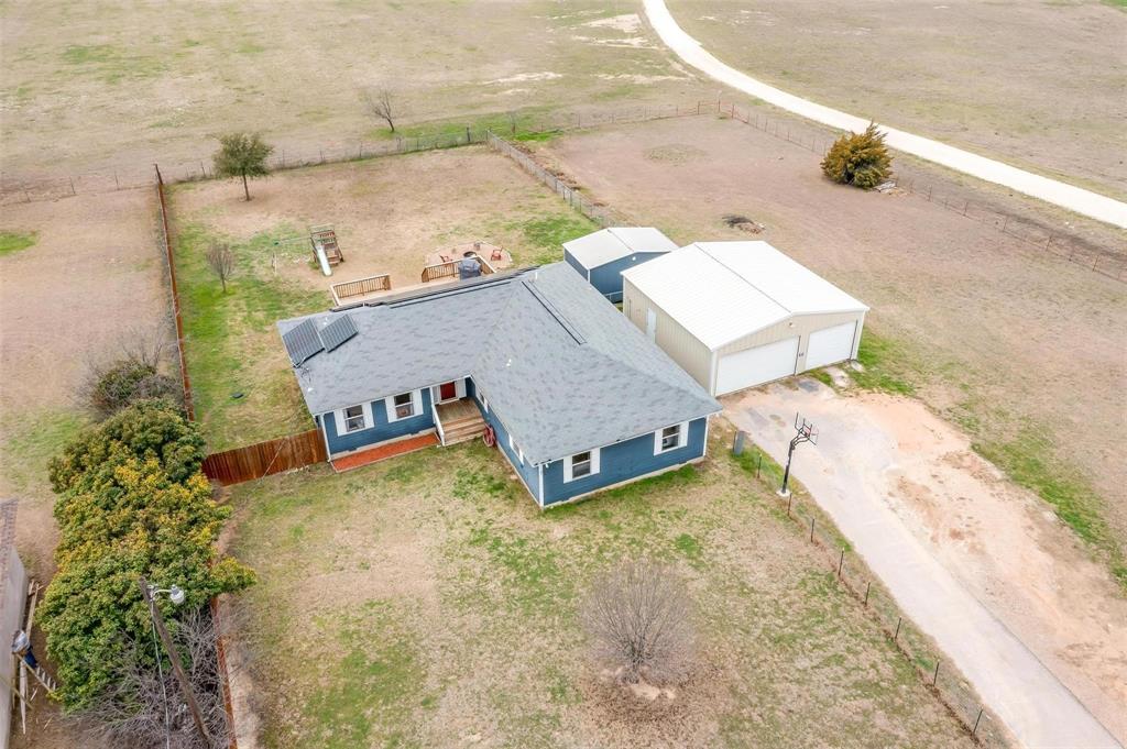 an aerial view of a house with a yard and sitting area