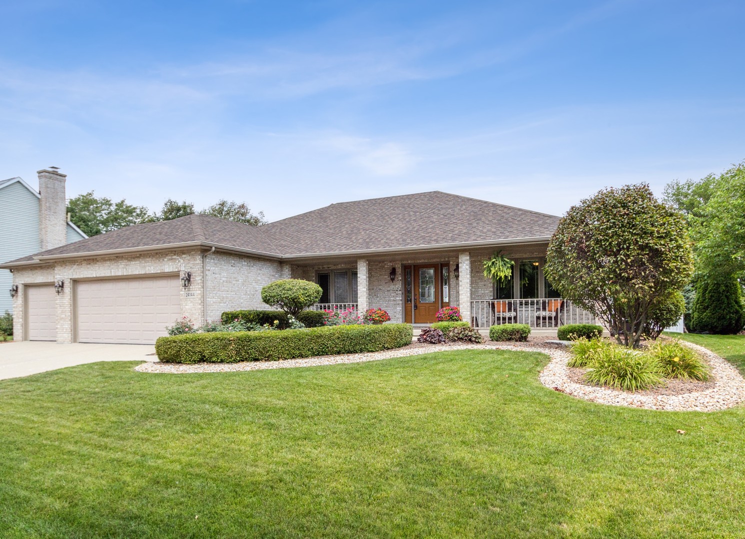 a front view of a house with a garden and sitting area