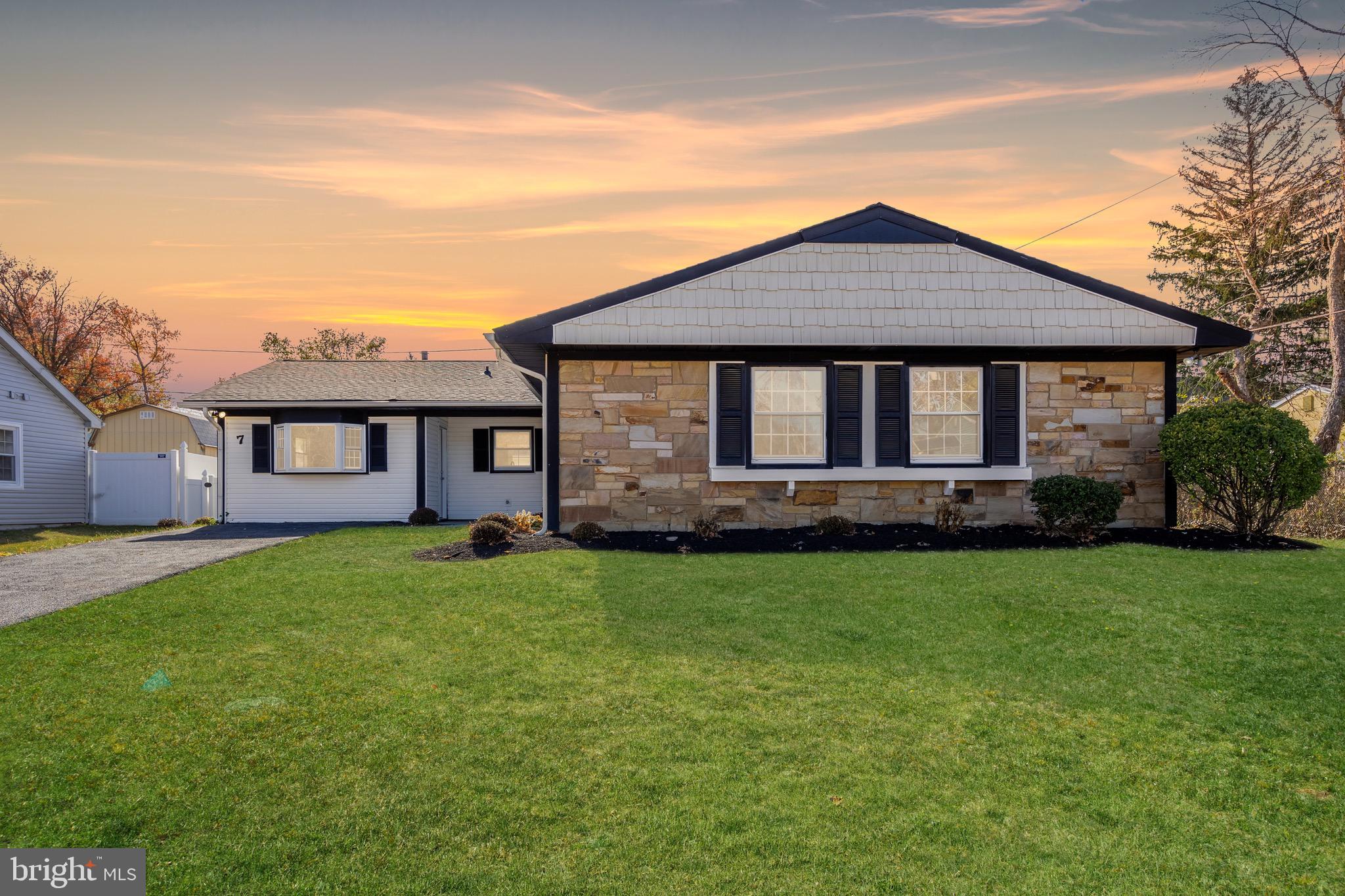 a front view of a house with yard and green space