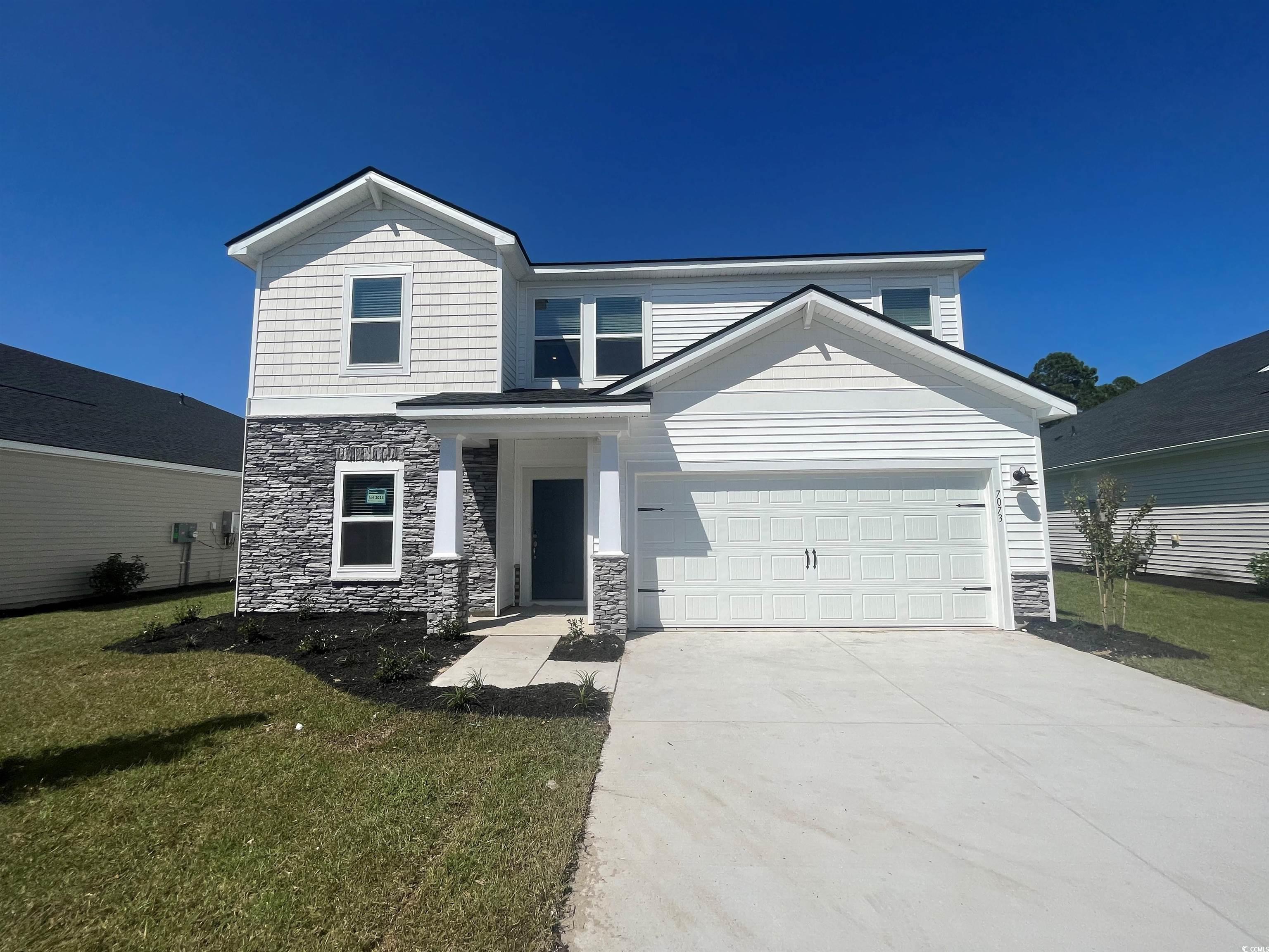 Front facade featuring a garage and a front lawn