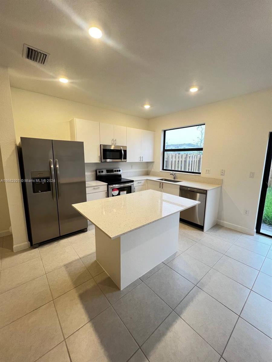 a kitchen with stainless steel appliances a refrigerator and a stove top oven