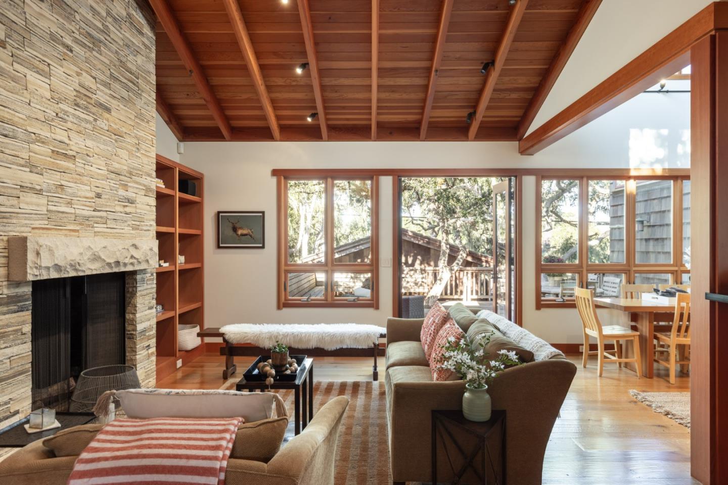 a living room with furniture a fireplace and a floor to ceiling window