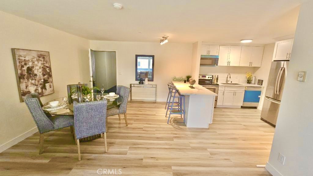 a living room with furniture wooden floor and a kitchen view