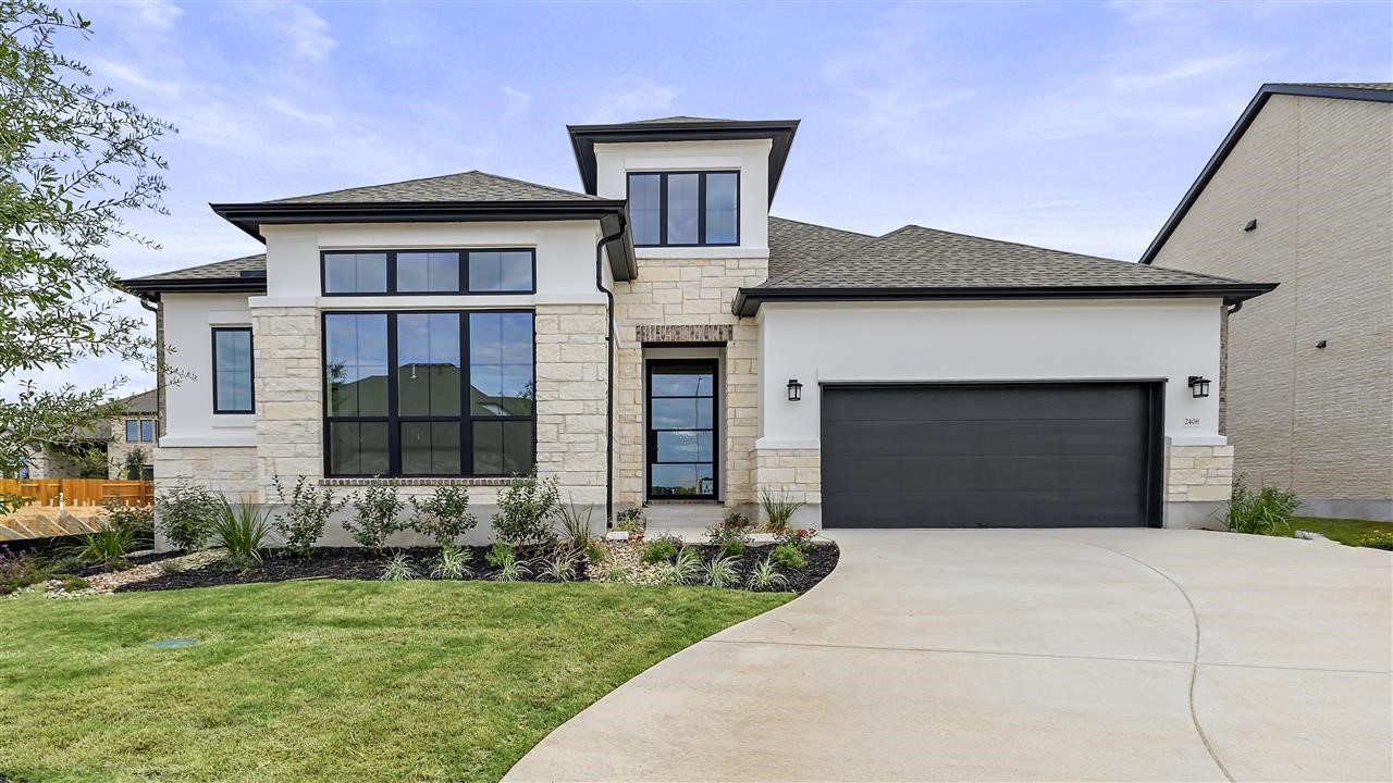 a front view of a house with a yard and garage