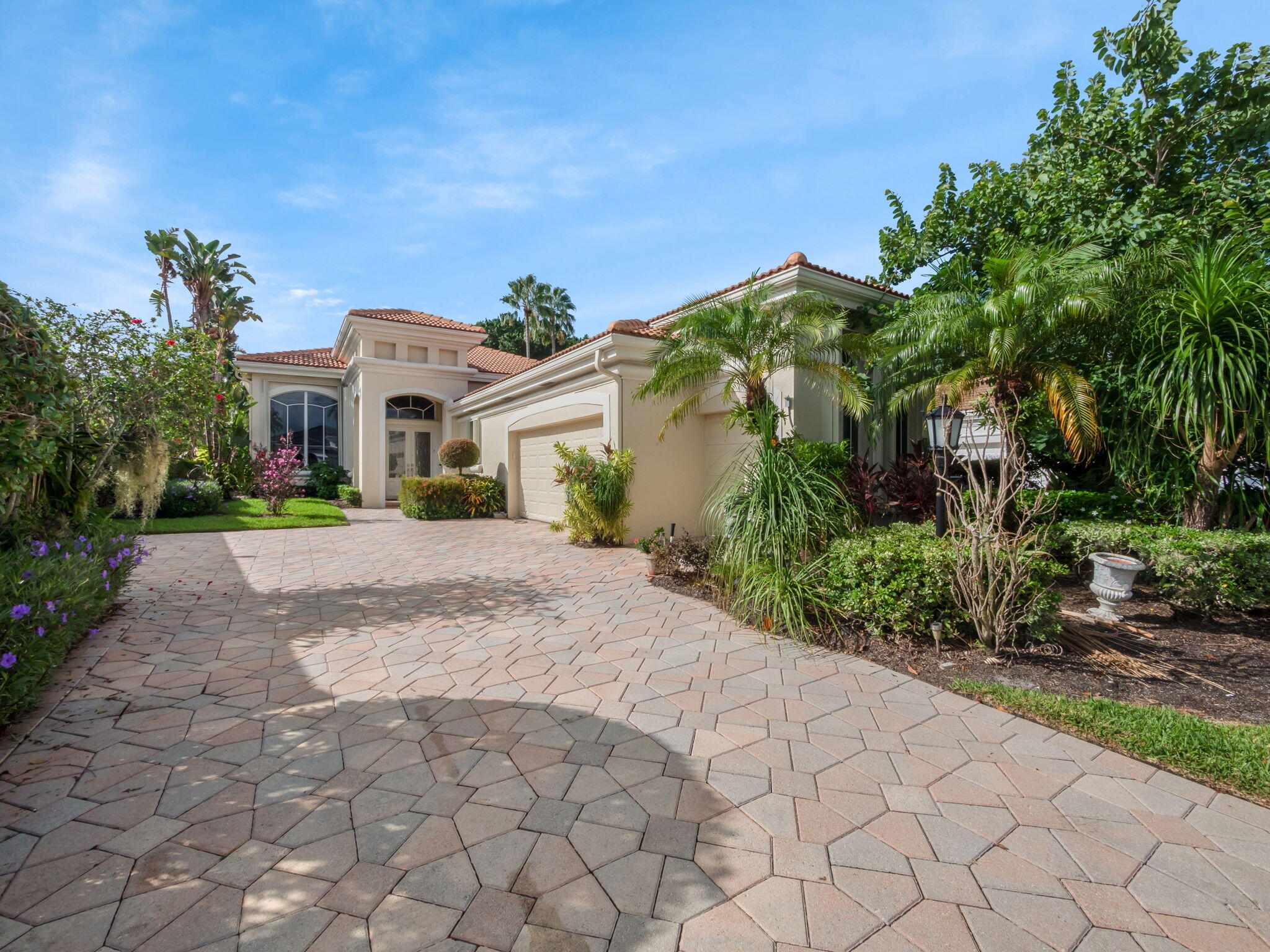 a front view of a house with a yard and a garden