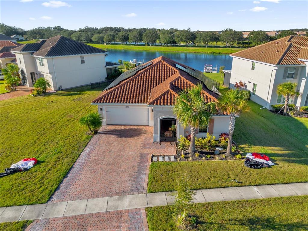 an aerial view of a house with a garden and lake view