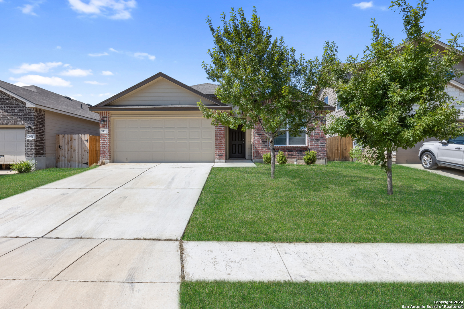 a front view of a house with a yard and trees