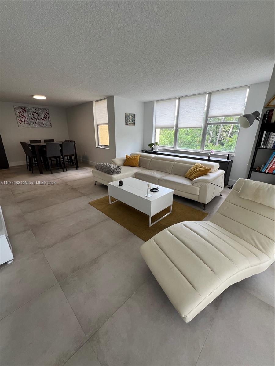 a living room with couches and large window with outer view