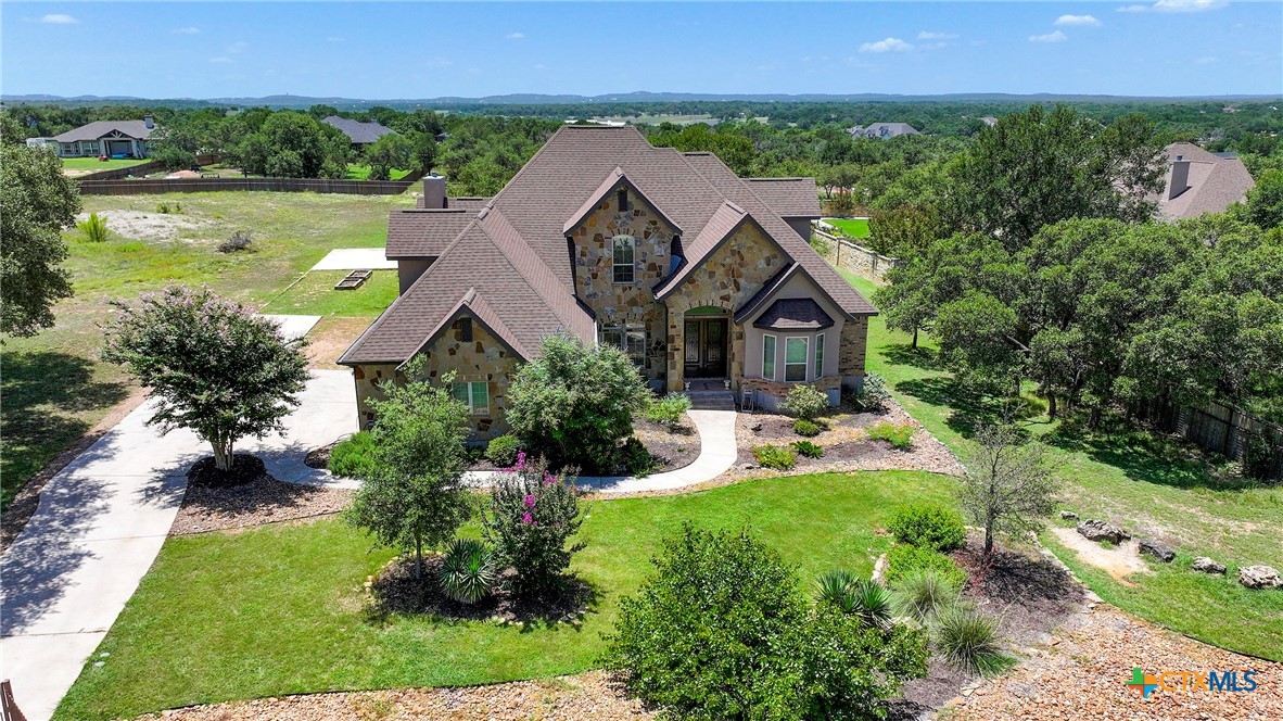 an aerial view of a house with garden space and a patio