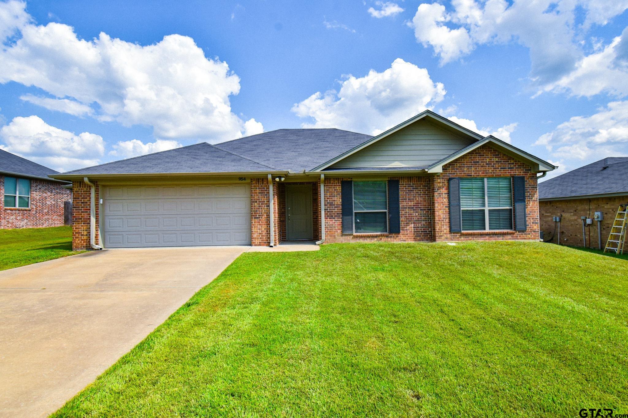 a front view of a house with a garden and yard