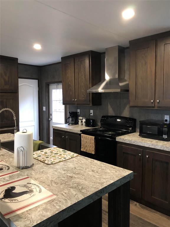 a kitchen with kitchen island granite countertop wooden cabinets and a stove