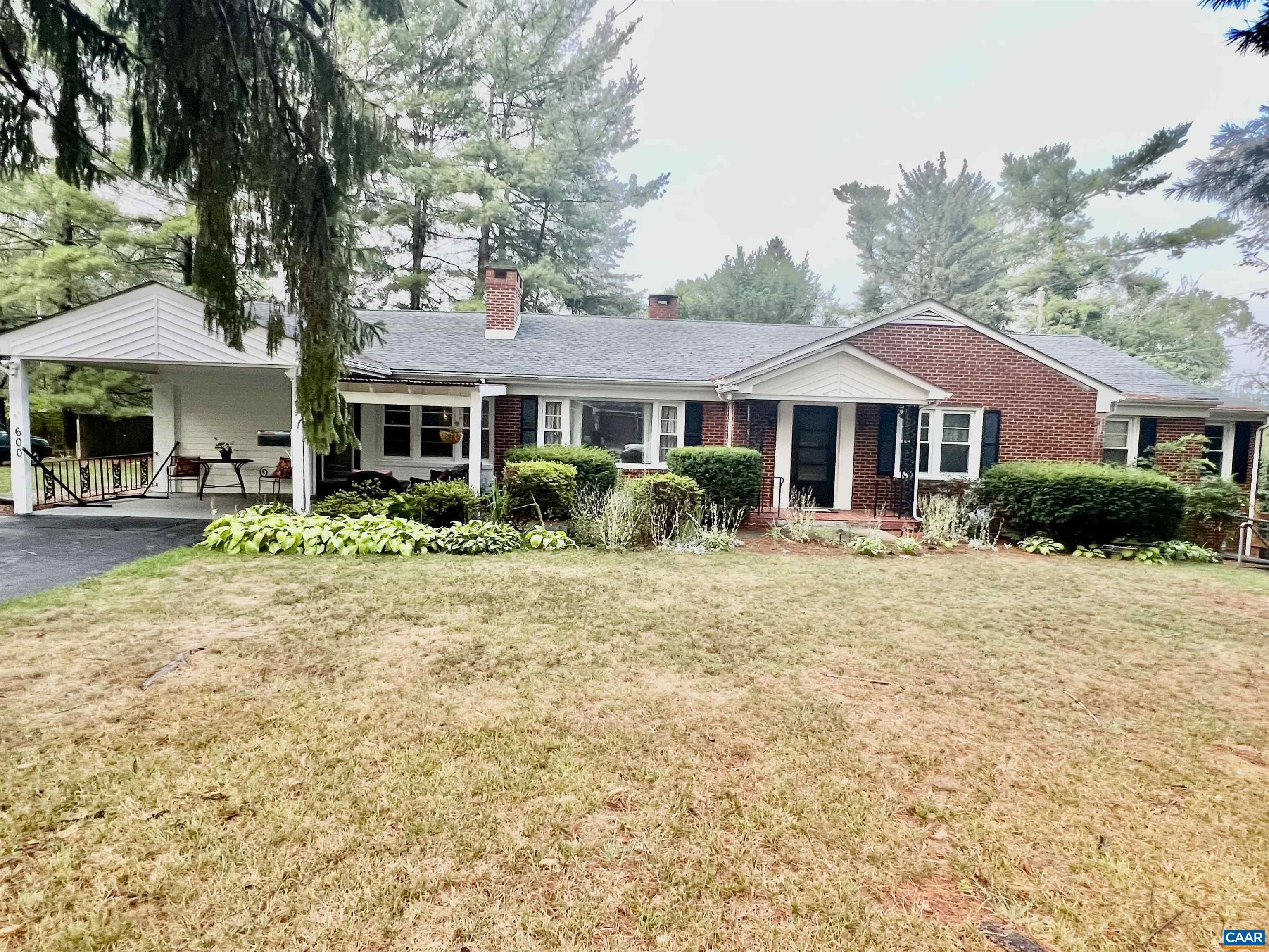 a front view of a house with a yard and trees