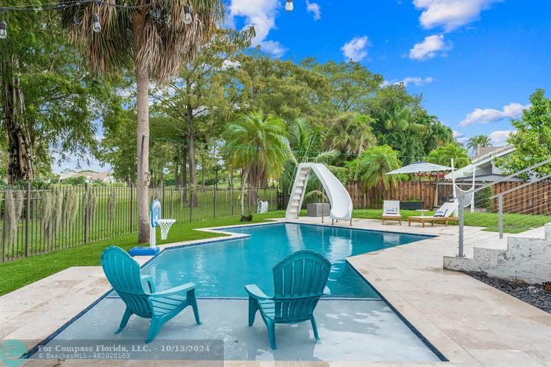 a view of a swimming pool with a patio and a yard