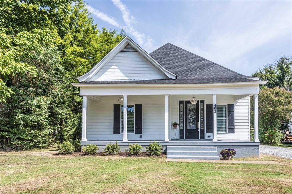 View of front of home with a porch and a front yard