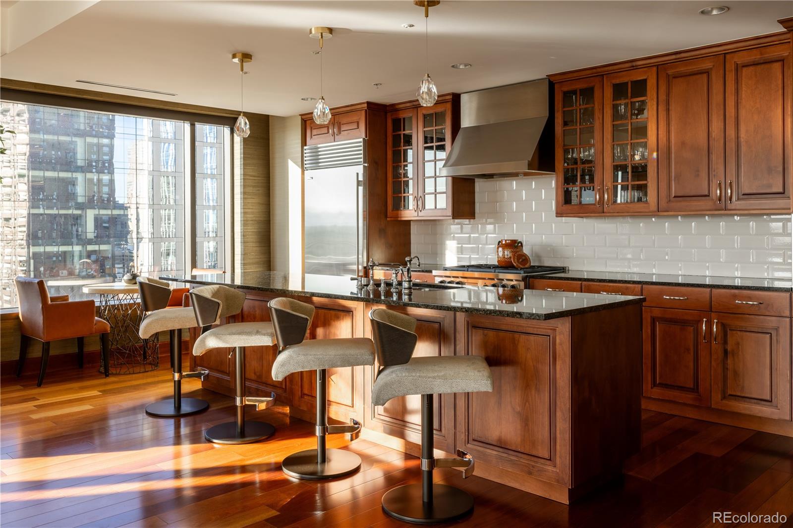 a kitchen with granite countertop a stove a sink and white cabinets with wooden floor