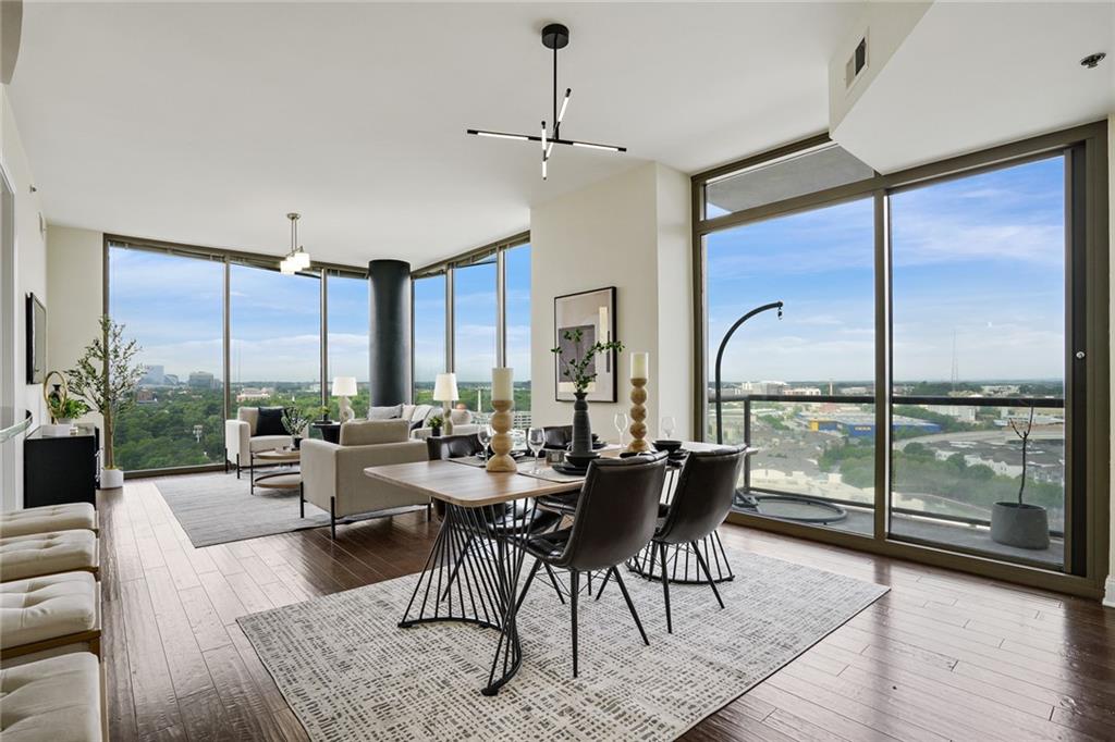 a very nice looking living room with a large window and dining table