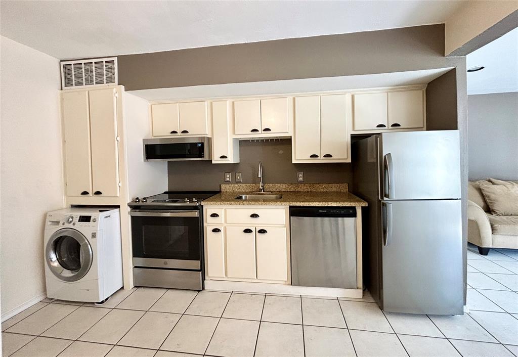 a kitchen with a refrigerator sink and cabinets