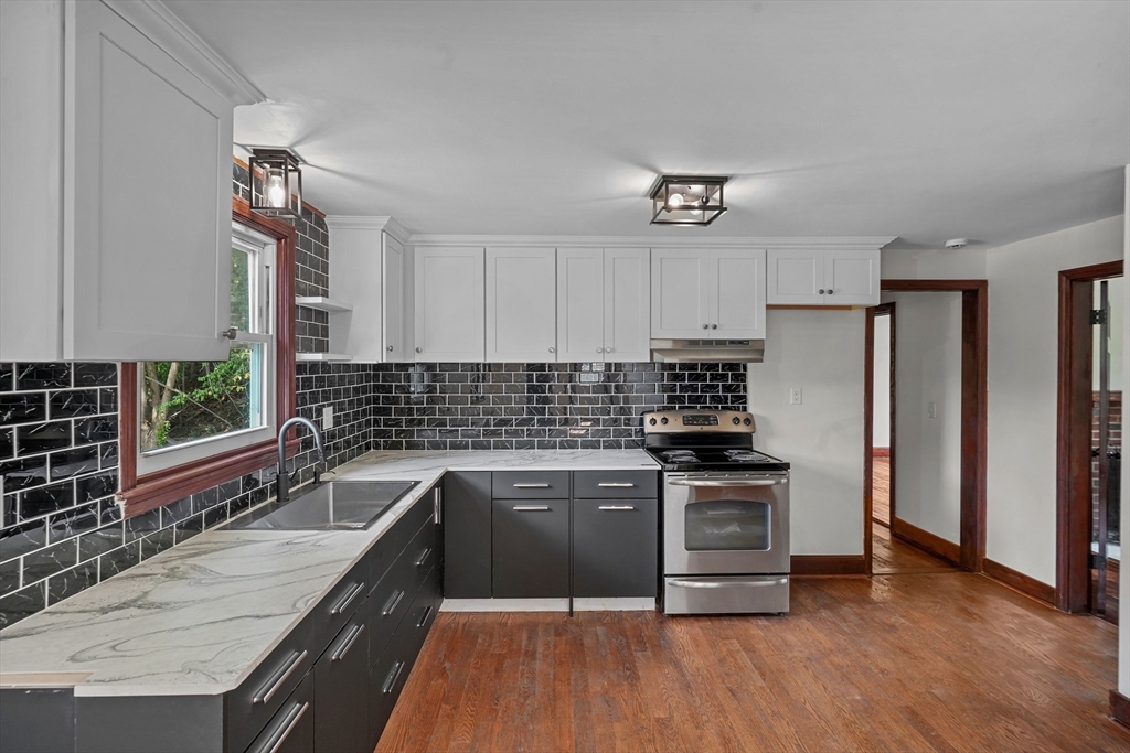 a kitchen with stainless steel appliances granite countertop a stove a sink and a refrigerator