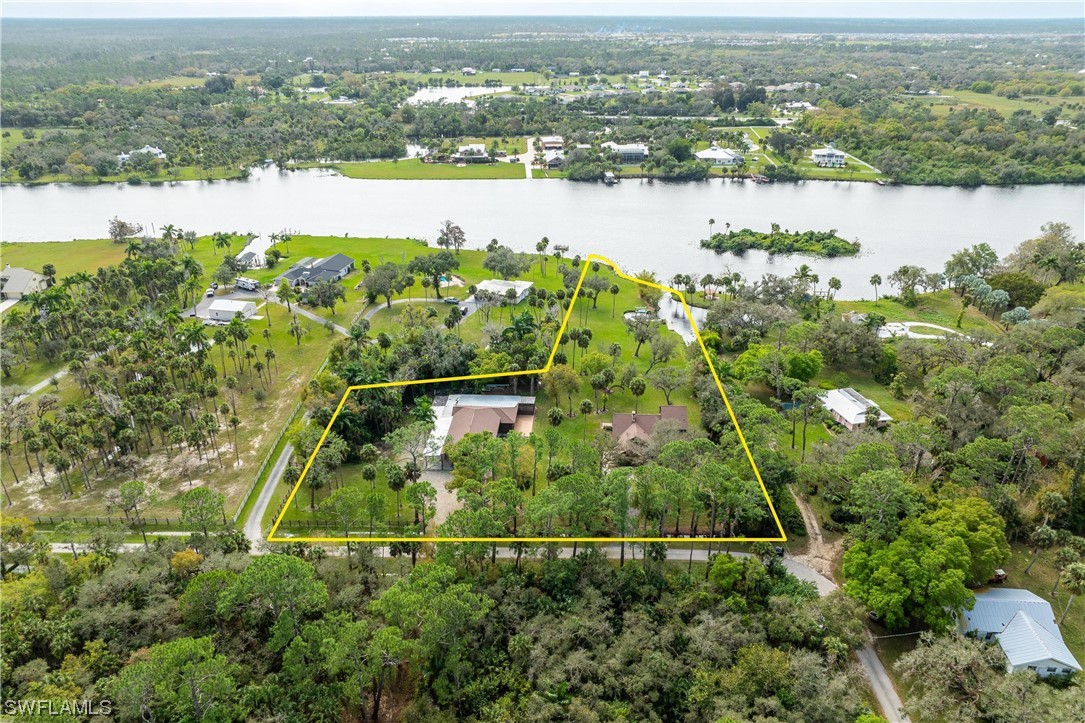 an aerial view of lake and residential houses with outdoor space and swimming pool