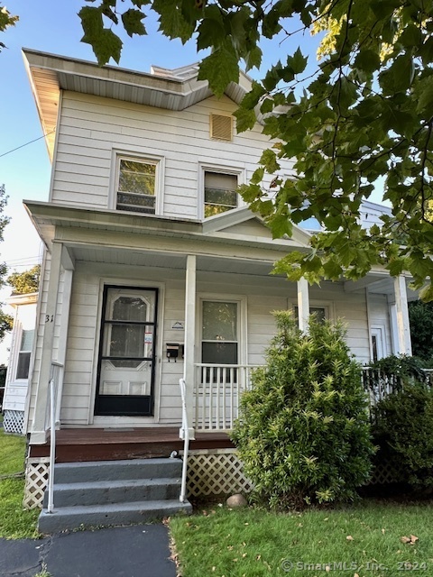 a front view of a house with a tree