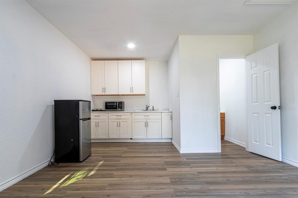 a kitchen with a refrigerator and white cabinets