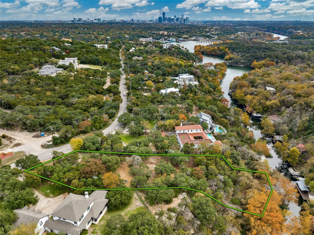 an aerial view of residential houses with outdoor space and trees