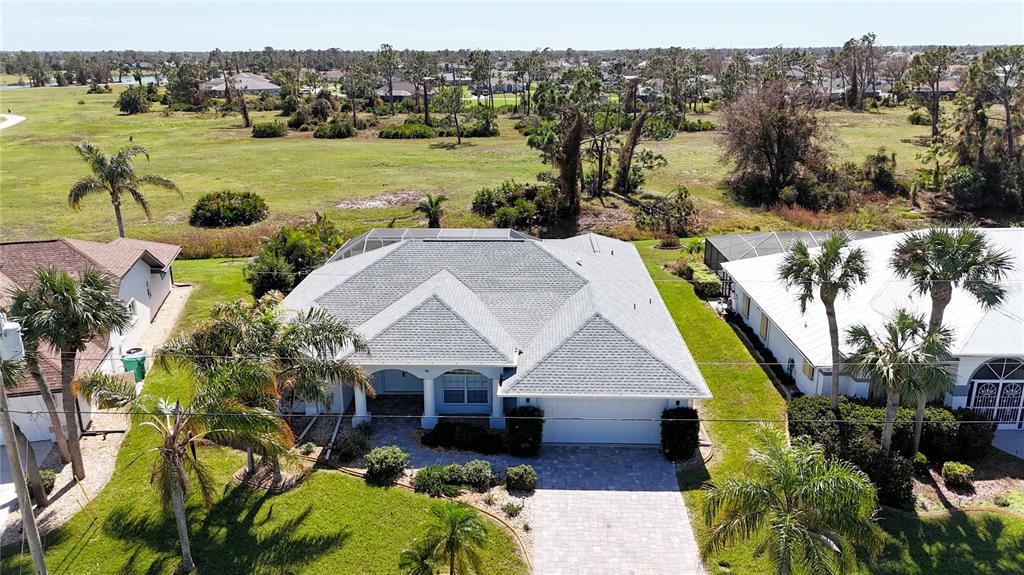 a aerial view of a house with a big yard and potted plants