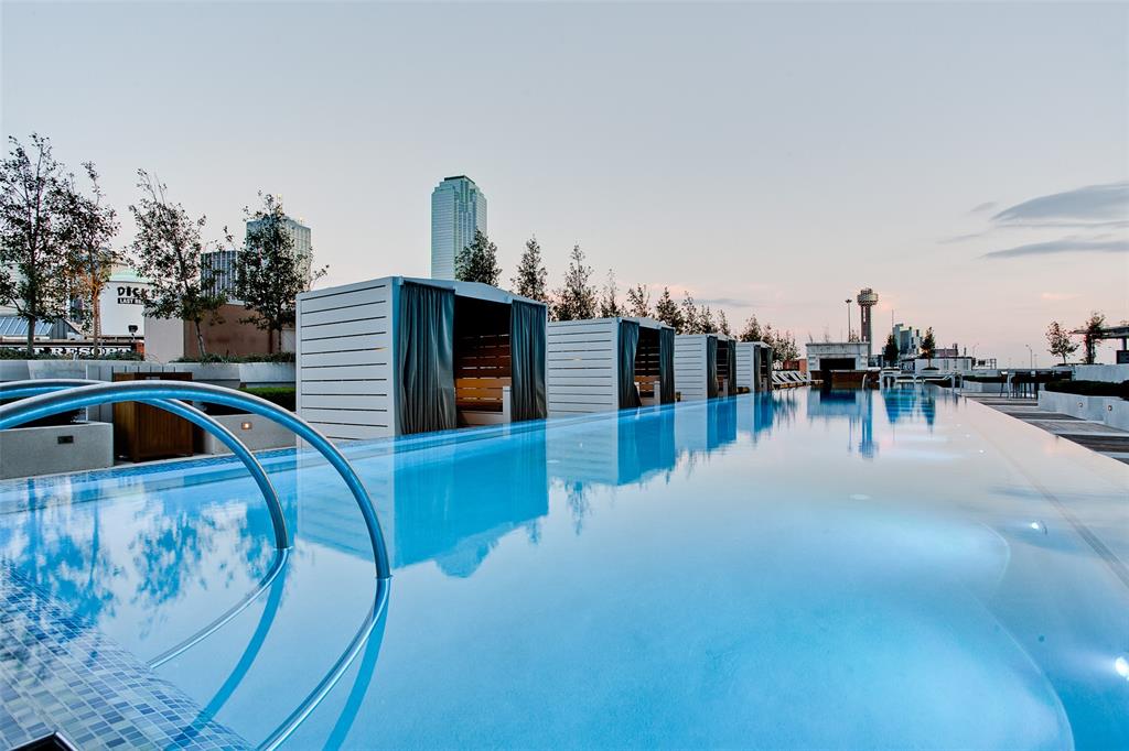 a view of a swimming pool with outdoor seating and trees