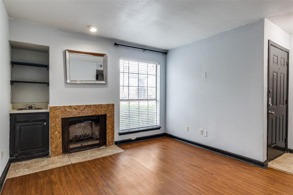 a view of an empty room with a fireplace and a window