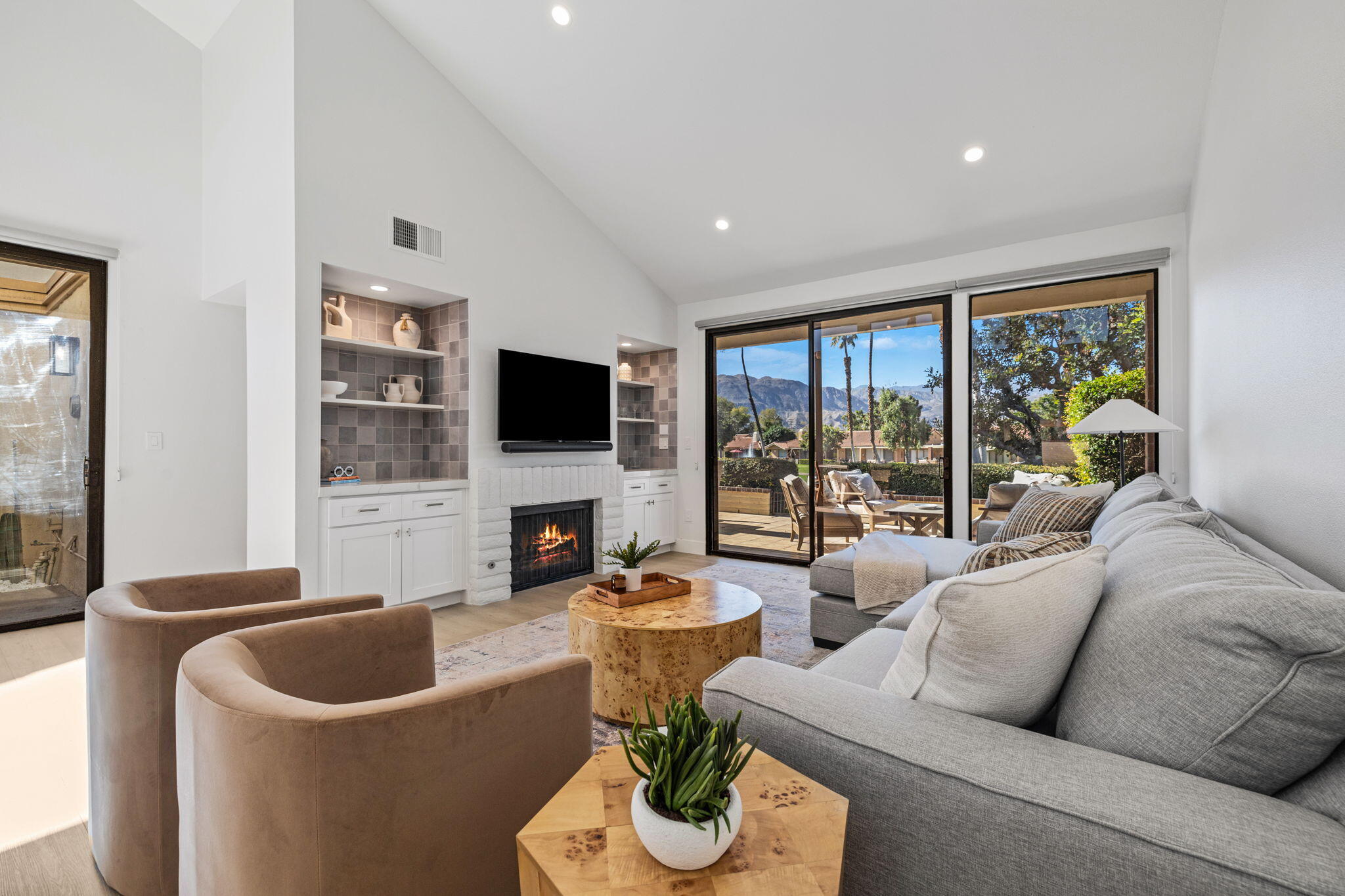 a living room with furniture a flat screen tv and a floor to ceiling window