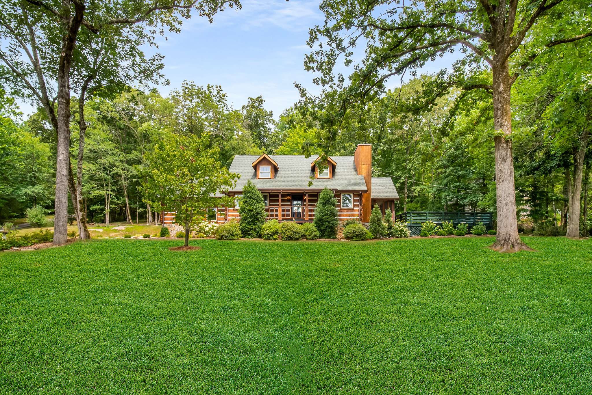 a aerial view of a house with a big yard and large trees