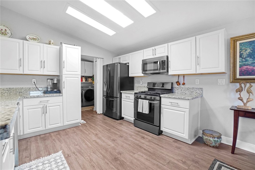 a kitchen with granite countertop white cabinets and stainless steel appliances