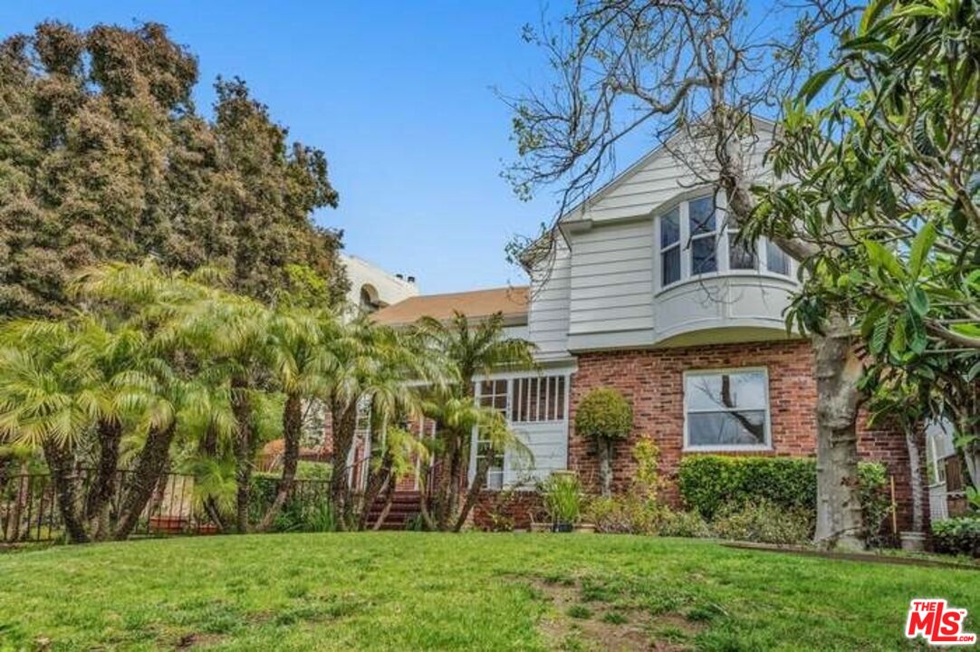 a front view of a house with a garden