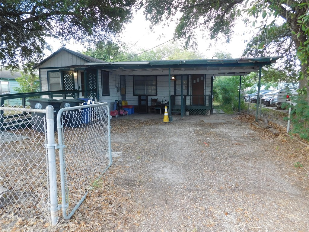 a view of patio with a table and chairs under an umbrella with wooden fence