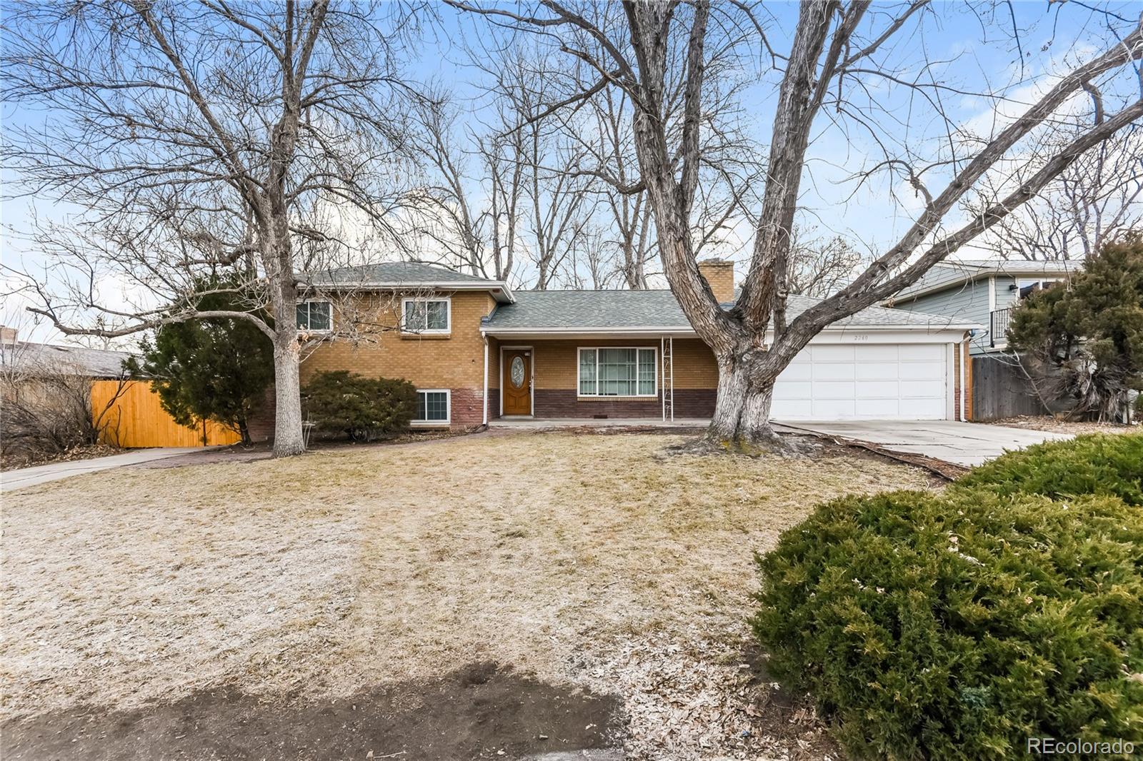 a front view of house with yard and trees around