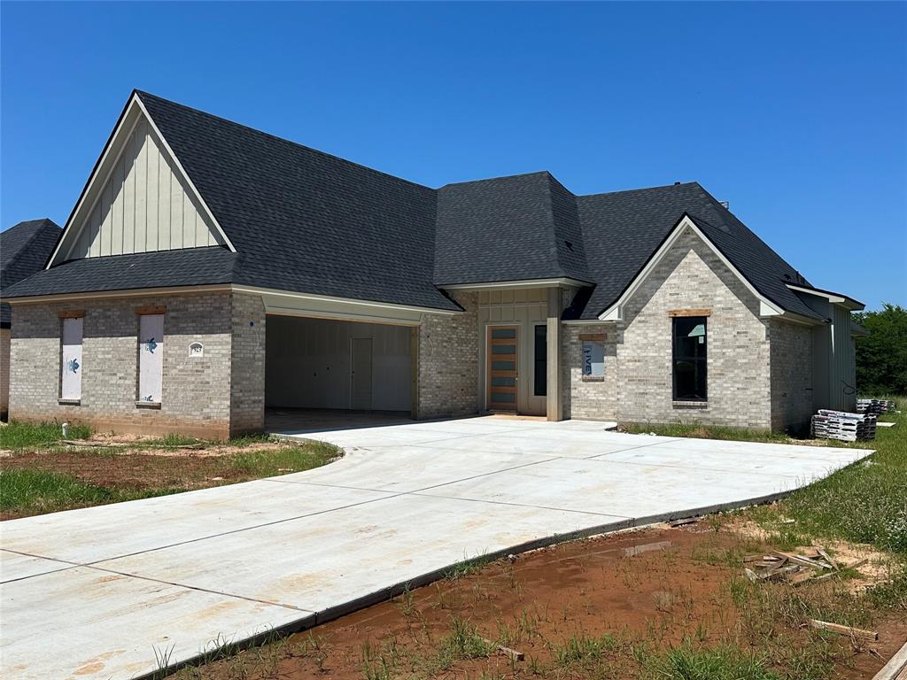 a front view of a house with yard and parking