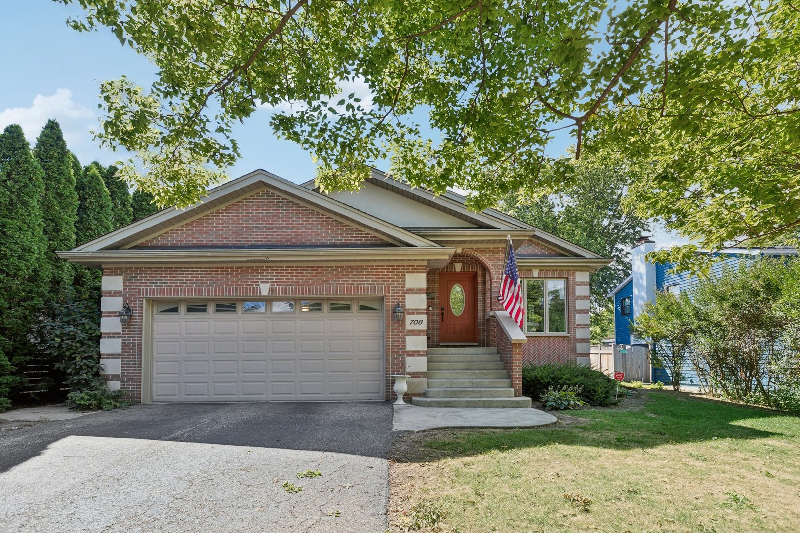 a front view of a house with a yard and trees