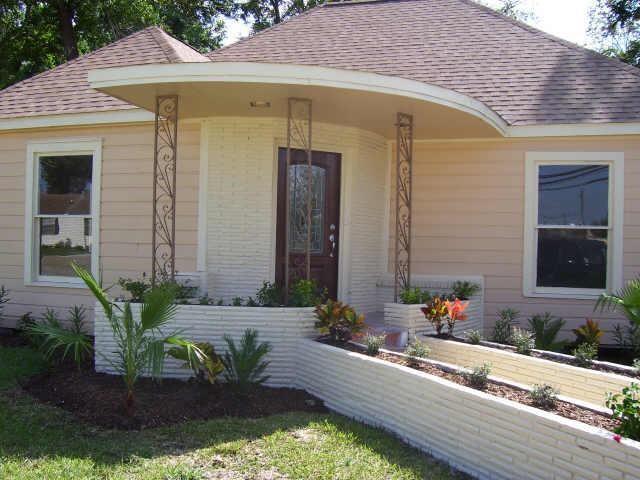 a front view of a house with lots of potted plants