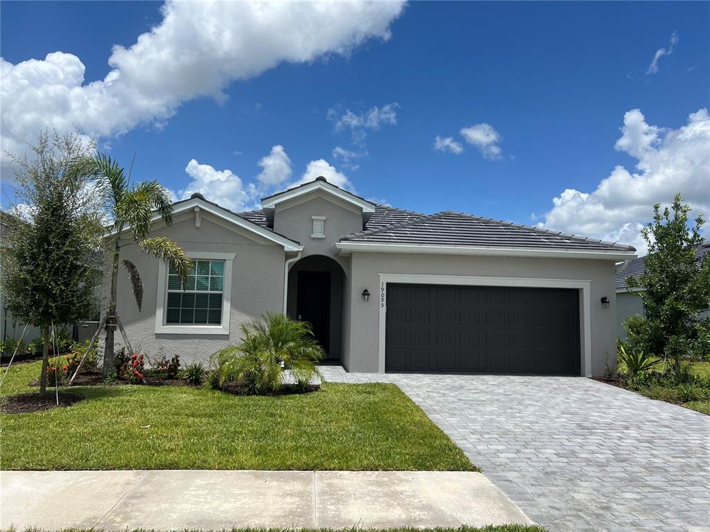 a front view of a house with a garden and yard