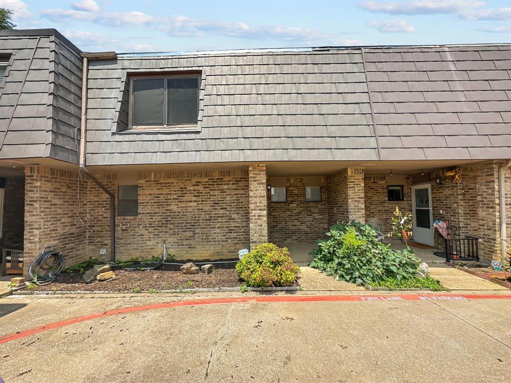 front view of a brick house with a small yard