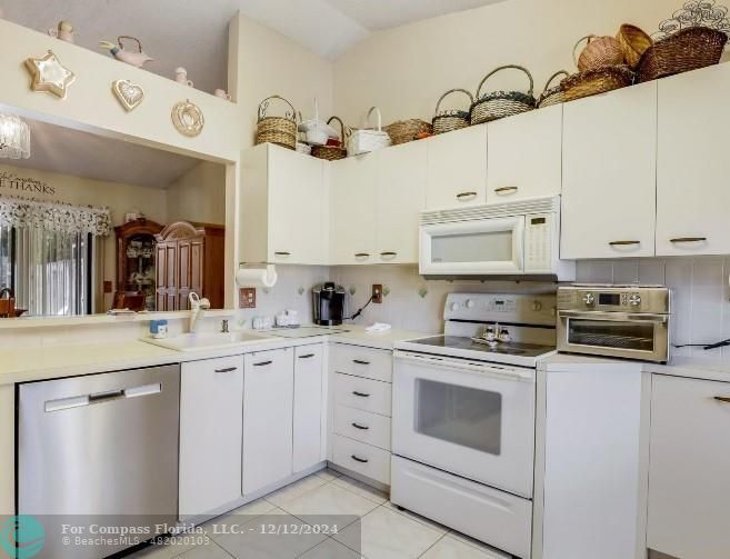 a kitchen with cabinets stainless steel appliances and wooden floor