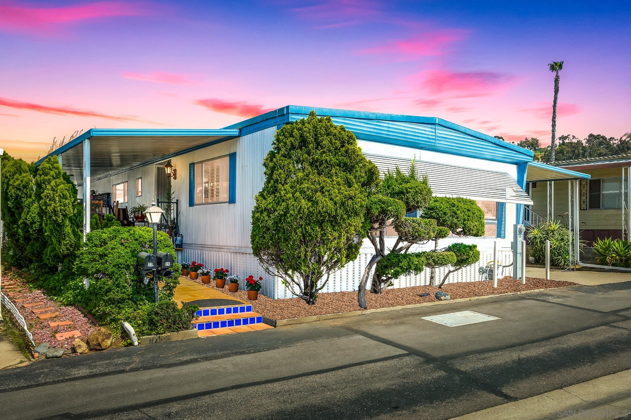 a front view of a house with a garden and plants