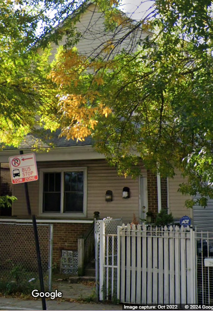 a front view of a house with a tree