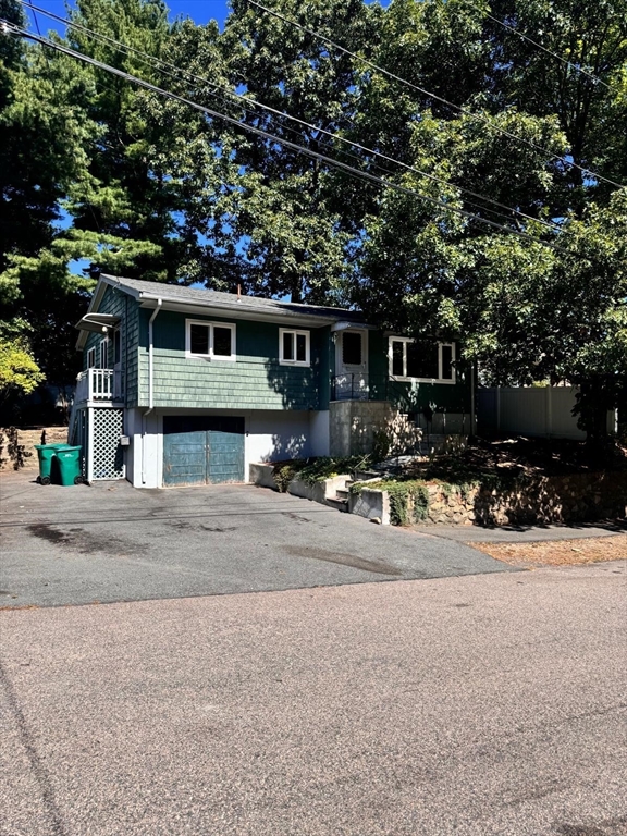 a front view of a house with lots of trees