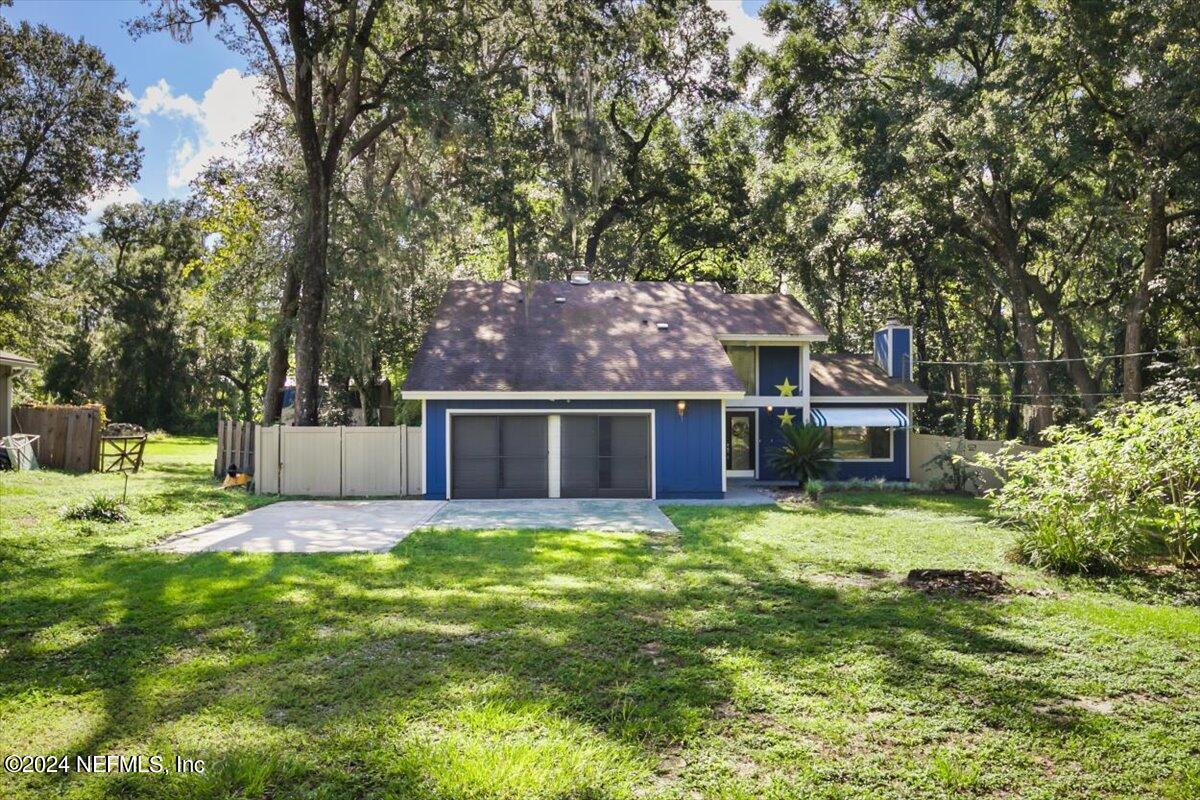 a view of a house with a yard and tree