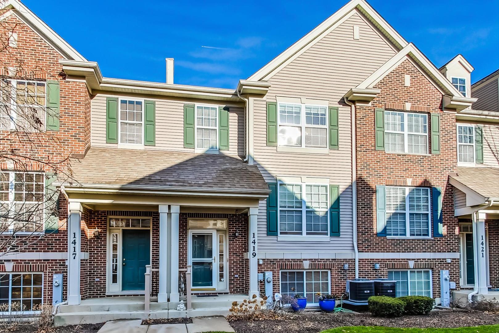 front view of a brick house with a yard